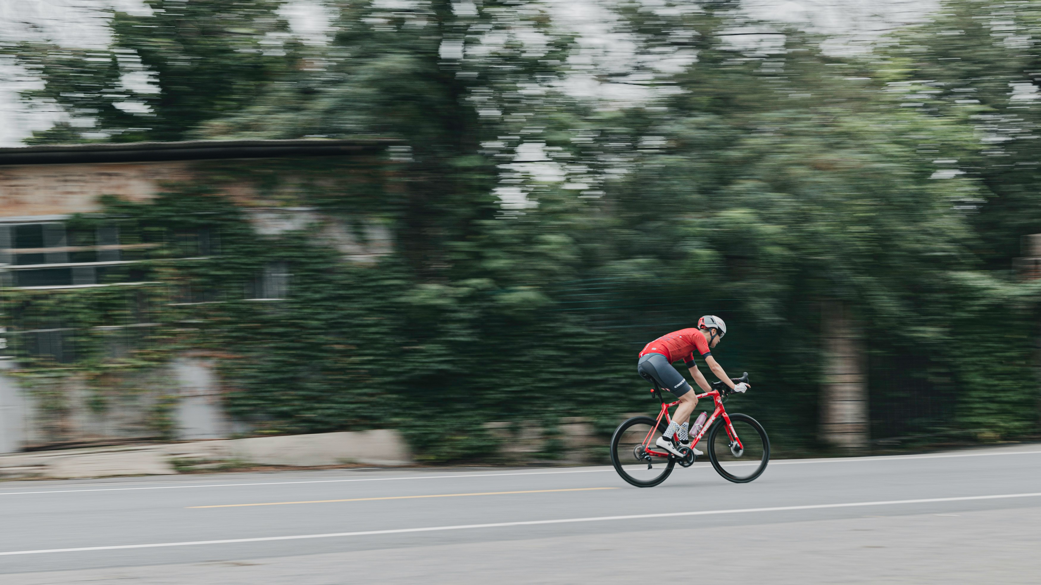 man in red shirt riding bicycle on road during daytime